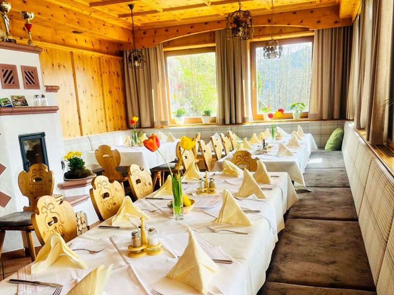 Neue Stube mit Kachelofen und schön gedeckten Tischen im Berggasthof Sonnenhof