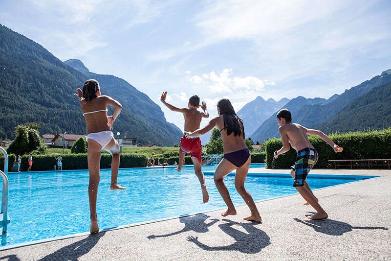 Kinder springen ins Becken im Freibad Pfunds