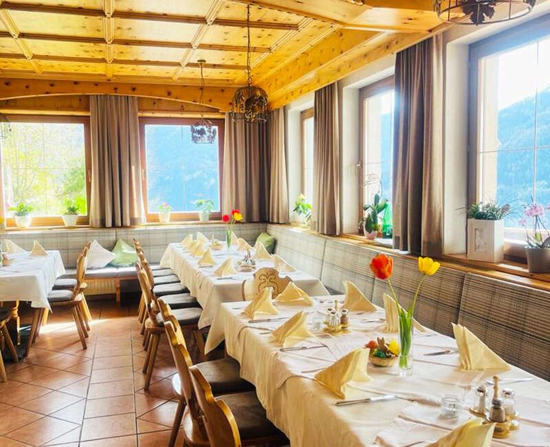 Neue Stube mit schön gedeckten Tischen und Ausblick auf die Bergwelt