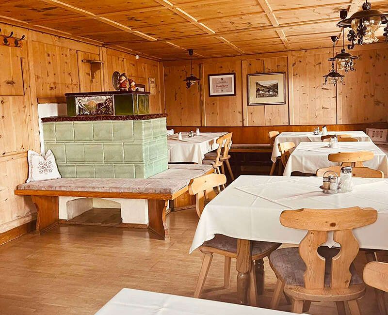 Alte Stube mit türkisem Kachelofen und Holzvertäfelung